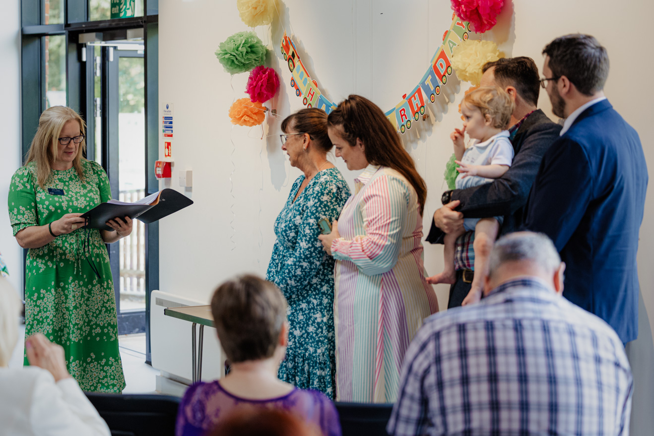 Deb Reed Celebrant Colchester Essex, officiating at Sebestians baby naming while he plays with his dad.